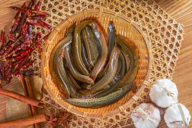 俯拍装在竹篓中的新鲜活泥鳅