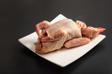 黑色背景上装在白色方盘中的新鲜鸽子食材