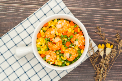 木桌背景一盘玉米胡萝卜炒虾仁