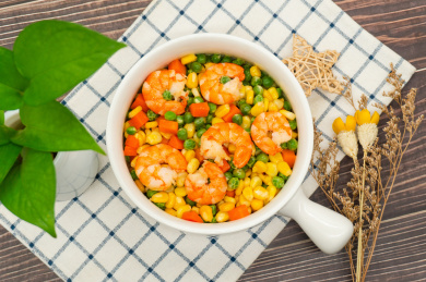 木桌背景一盘玉米胡萝卜炒虾仁