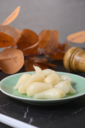 桌面上的盘子里的美味可口的甜酸荞头