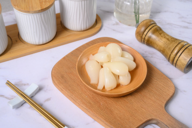 桌面上的盘子里的美味可口的甜酸荞头