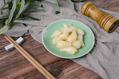 桌面上的盘子里的美味可口的甜酸荞头