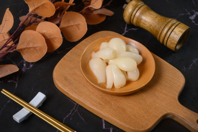 桌面上的盘子里的美味可口的甜酸荞头