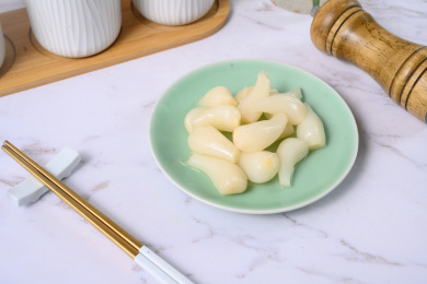 桌面上的盘子里的美味可口的甜酸荞头