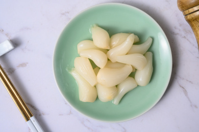 桌面上的盘子里的美味可口的甜酸荞头