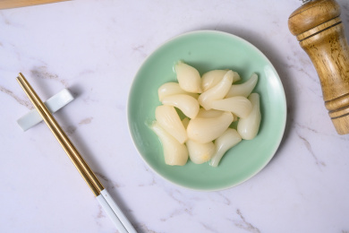 桌面上的盘子里的美味可口的甜酸荞头