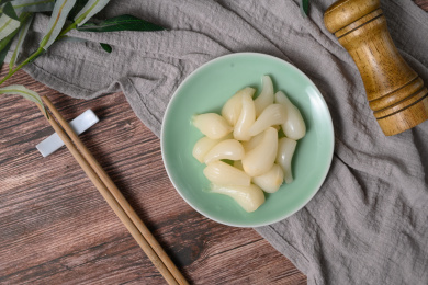 桌面上的盘子里的美味可口的甜酸荞头