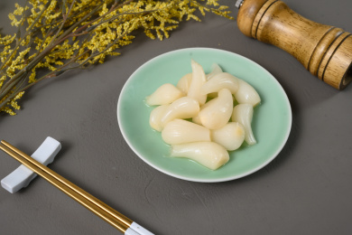 桌面上的盘子里的美味可口的甜酸荞头