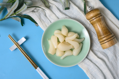 桌面上的盘子里的美味可口的甜酸荞头