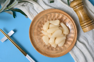 桌面上的盘子里的美味可口的甜酸荞头