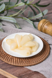 桌面上的盘子里的美味可口的甜酸荞头