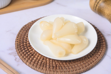 桌面上的盘子里的美味可口的甜酸荞头