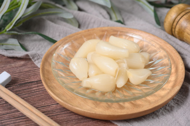 桌面上的盘子里的美味可口的甜酸荞头