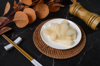 桌面上的盘子里的美味可口的甜酸荞头