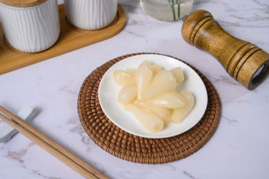 桌面上的盘子里的美味可口的甜酸荞头