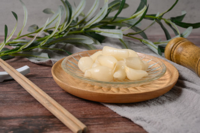 桌面上的盘子里的美味可口的甜酸荞头