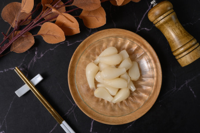 桌面上的盘子里的美味可口的甜酸荞头