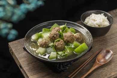 家常菜冬瓜丸子汤摆放在木桌面上特写