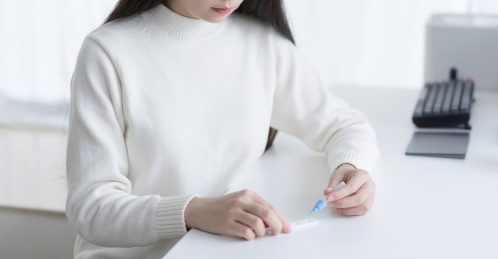 女人手拿样本提取管在做抗原自测