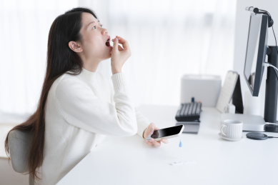 穿白色毛衣的女人张开嘴巴在做抗原检测