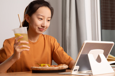 看着电脑准备吃东西的亚裔女人面带微笑