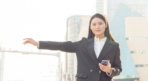 城市中伸手搭车的商务青年女白领