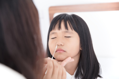 小女孩配合妈妈做抗原测试