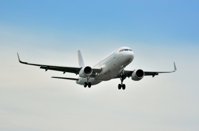 蓝天白云下一架纯白客机降落特写