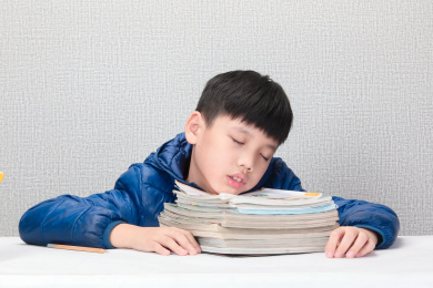 趴在课本上睡觉的小孩