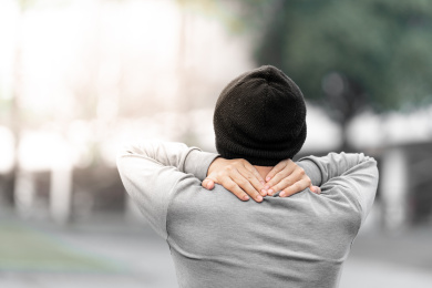 男子在户外捂住脖子，疼痛示意