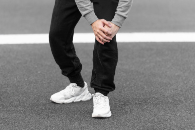 亚洲男青年在户外扶住膝盖