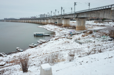 在白雪覆盖的陶家大湖中延伸的桥梁