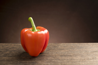 红色彩椒摆放在木桌面上特写