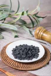 桌面上的盘子里的美味可口的黑加仑葡萄干