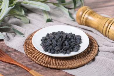 桌面上的盘子里的美味可口的黑加仑葡萄干