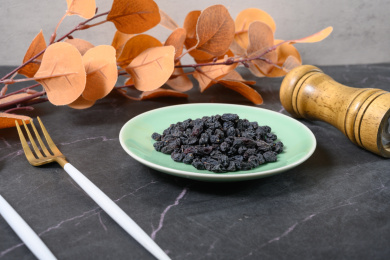 桌面上的盘子里的美味可口的黑加仑葡萄干