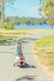 湖畔树林小道开摩托车的小孩
