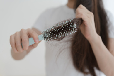 女人手拿着梳子梳头发