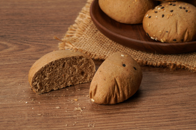 实木桌上摆着的一堆切开的小圆面包