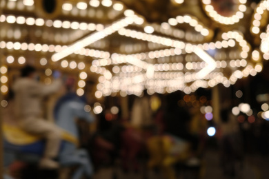 虚化模糊的人在夜晚的旋转木马上