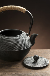 一把铁壶茶具摆放在木桌面上特写