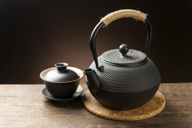 一把铁壶茶具摆放在木桌面上特写