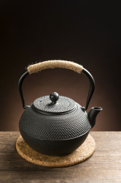 一把铁壶茶具摆放在木桌面上特写