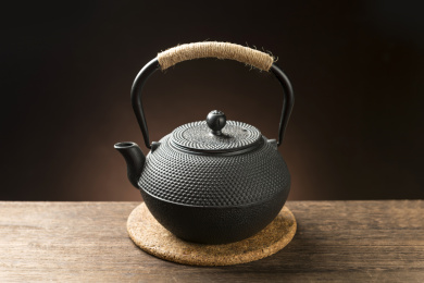 一把铁壶茶具摆放在木桌面上特写
