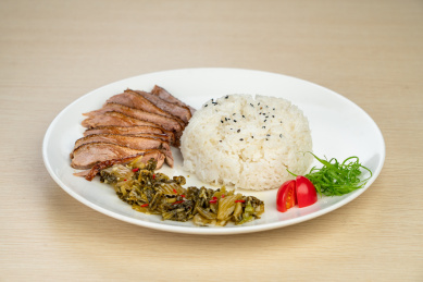 放在白色盘子上的鹅肉饭