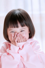 一个捂着嘴笑的亚洲小女孩