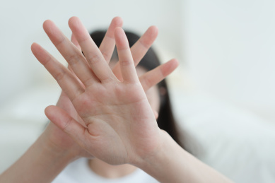 女人手举前面做拒绝手势试图保护自己
