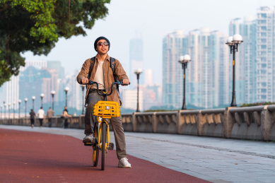 亚洲男生在江边骑自行车