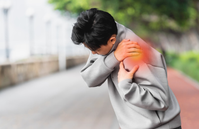 亚洲运动男生在户外捂住肩膀